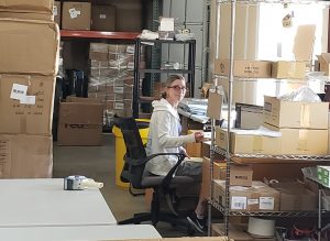 Terri sitting her desk in her Vancouver warehouse