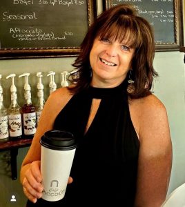 Jodi Vaughan, owner of Caffe Piccolo, a coffee shop in Camas, holding a to go coffee