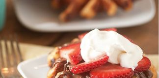 liege waffle with strawberries and whipped cream on a plate