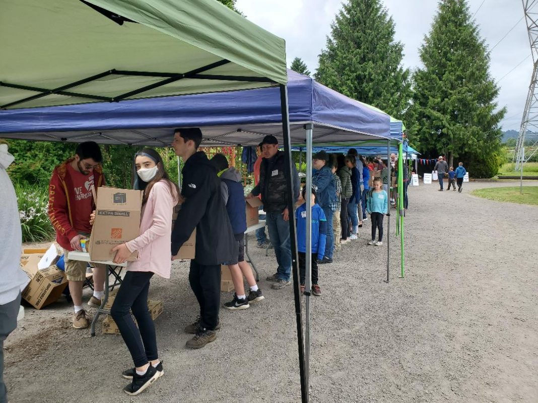 lines of volunteers with boxes of food under pop-up tents for IMPACT Camas-Washougal 2021