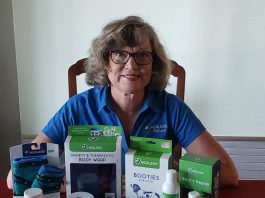 Terri sitting at a table with Healer's Pet Care products in front of her