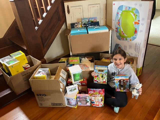 Lily Strickland city with boxes of donated toys
