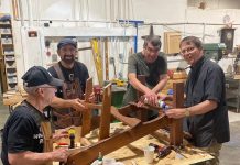 men working on building a wooden chair at Friends of the Carpenter