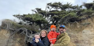 Jane and Lucas Shuler and their two kids standing by the Tree of LIfe in Kalaloch Campground