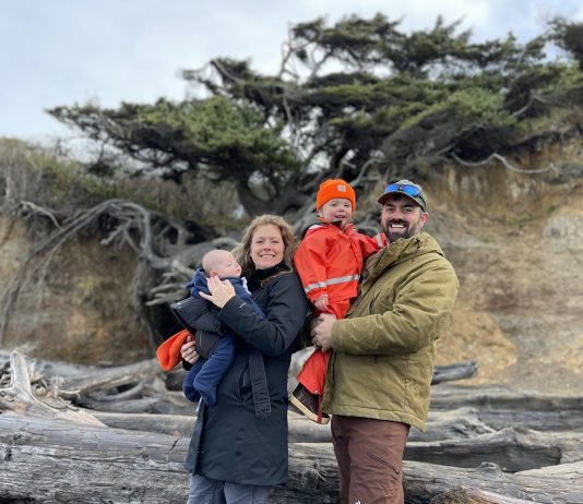 Jane and Lucas Shuler and their two kids standing by the Tree of LIfe in Kalaloch Campground