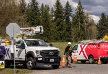 comcast and xfinity trucks with workmen by the roadway