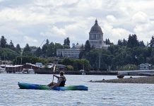Kayaker on Budd Bay with the Olympia Capitol building in the background