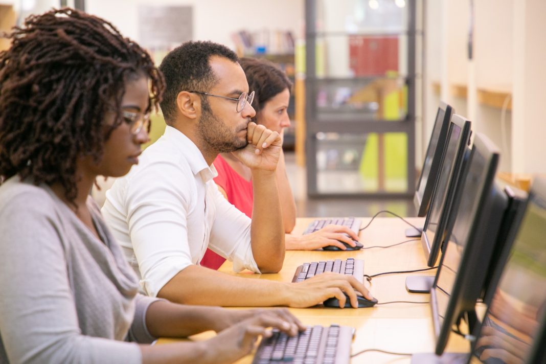 students at computers on a long desk